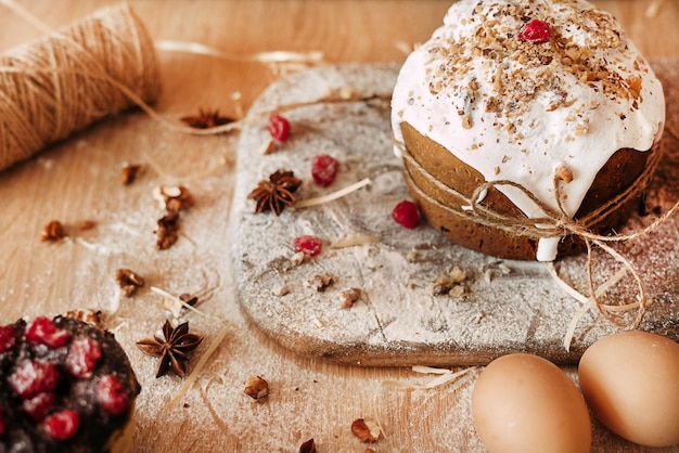 Easter composition easter cake eggs dried fruits and a bale rope of flour stand on a wooden table