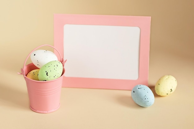 Easter composition from decorative bucket full of eggs and blank card with copy space on background