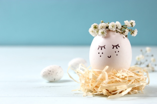 Easter composition of painted eggs and feathers on a colored background