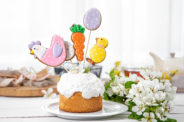 Easter composition with beautifully decorated Easter cake and spring flowers. The concept of preparing for the Easter holiday.