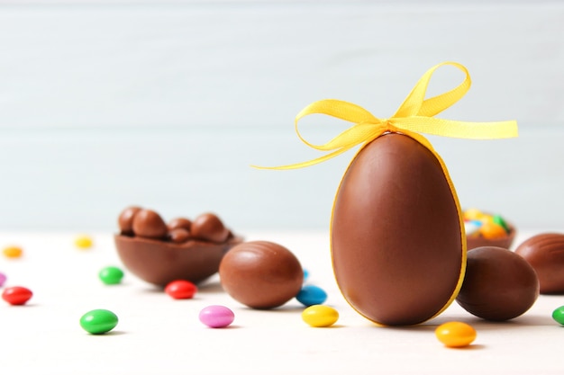 Composizione pasquale con uova di cioccolato e coniglio al cioccolato su fondo di legno