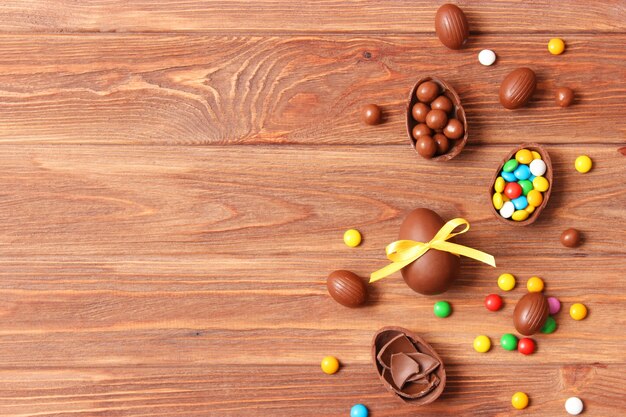 Easter composition with chocolate eggs and chocolate rabbit on wooden background