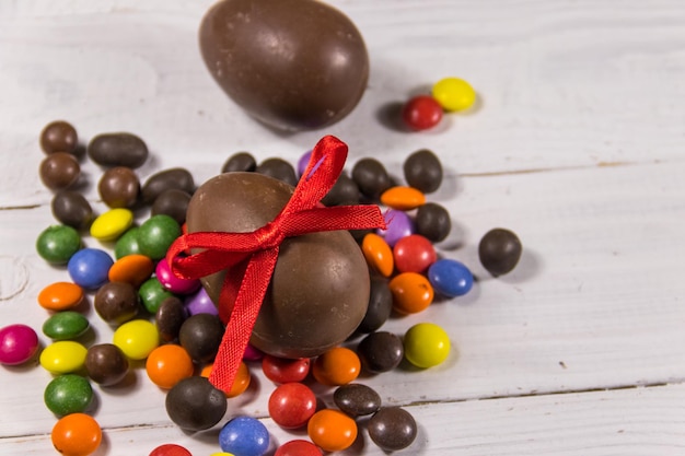 Easter composition with chocolate eggs on white wooden background