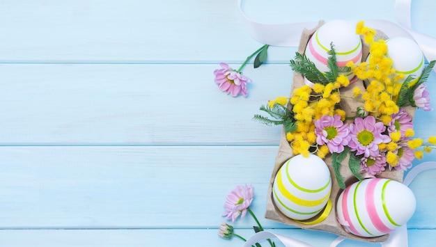 Photo easter composition with easter eggs and flowers