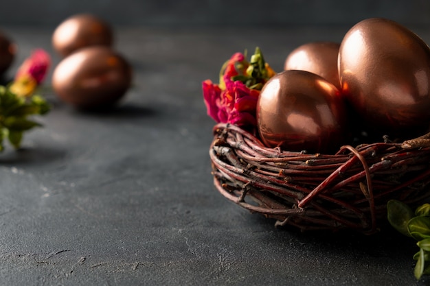 Пасхальная композиция с яйцами в гнезде и перо на темном фоне. Пасхальная открытка