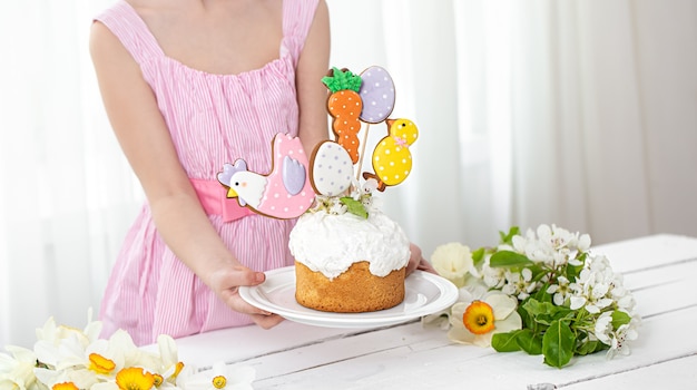 Composizione di pasqua con una torta festiva, decorata con pan di zenzero su bastoncini. il concetto di preparazione per le vacanze di pasqua.