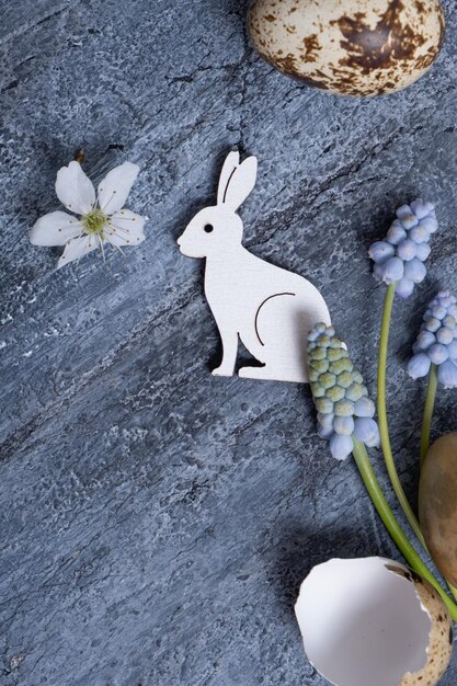 Easter composition with flowers white rabbit and eggs flat lay top view