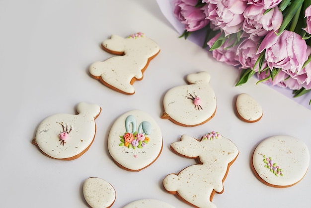 Composizione pasquale con pane dolce conigli di pan di zenzero e uova bouquet di fiori tulipano vacanze colazione biscotti pasquali tradizionali di pan di zenzero modello biglietto di auguri di pasqua