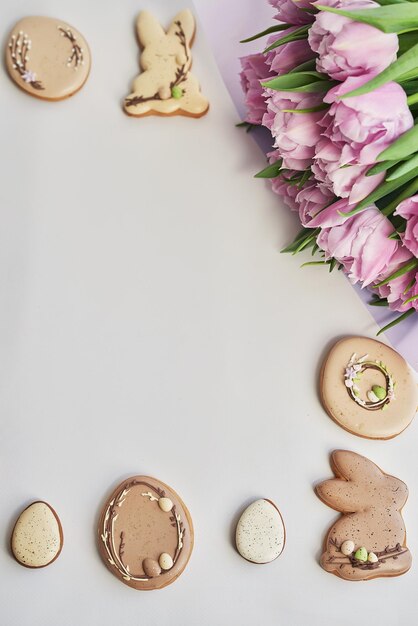 Easter composition with sweet bread gingerbread rabbits and eggs bouquet of flowers tulip Holidays breakfast Traditional easter gingerbread cookies Easter Greeting Card Template