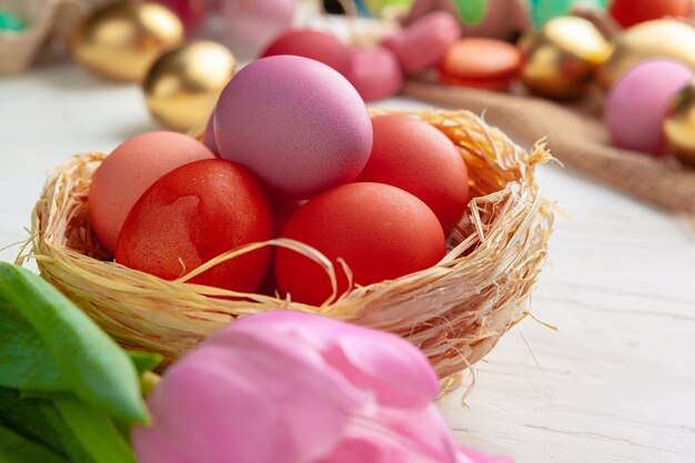 Easter composition with tulips and basket of painted eggs