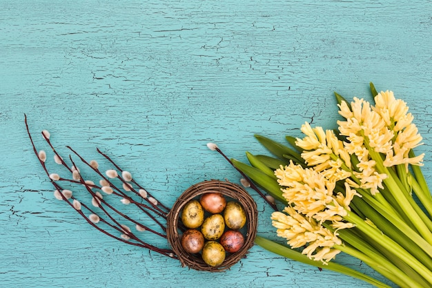 Easter composition with yellow hyacinths, pussy-willow and Easter eggs. Top view, copy space.