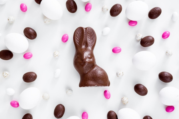 イースターのコンセプトは、白い背景の上のチョコレートバニーの卵とお菓子のクローズアップ