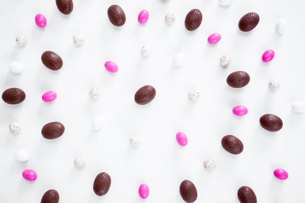 Easter concept - close up of eggs and sweets over white background