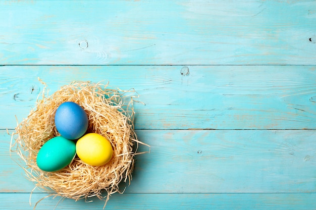 Easter concept. Colorful eggs on blue wooden background with copy space for text. Top down view or flat lay