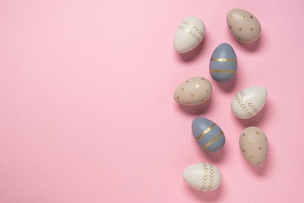 Photo easter concept. decorated eggs stand in a row on pink background.