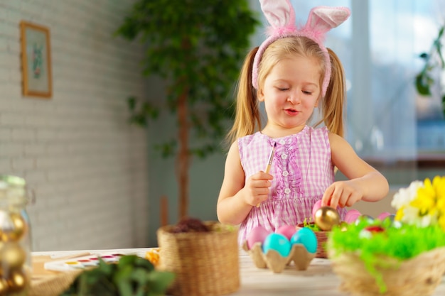 Concetto di pasqua. ragazza felice bionda del bambino con le orecchie del coniglietto