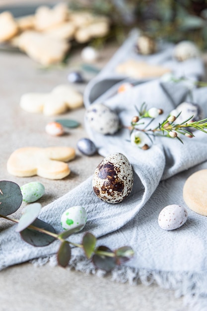 Easter cookies with candies shaped eggs floral decor and quail eggs Holiday concept