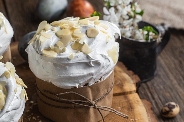 Easter cupcake with meringue and almond petals on a wooden background