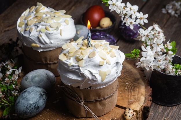 Easter cupcake with meringue and almond petals on a wooden background