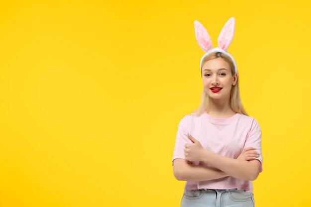 Easter cute young blonde girl wearing pink bunny ears smiling with crossed hands