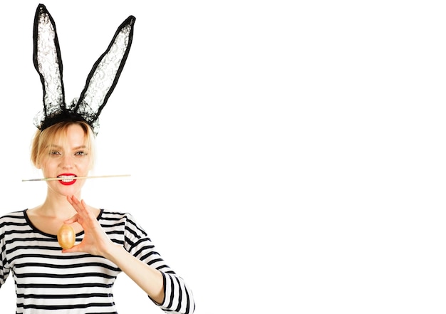 easter day bunny girl in black lace rabbit ears with painted egg and paint brush in mouth