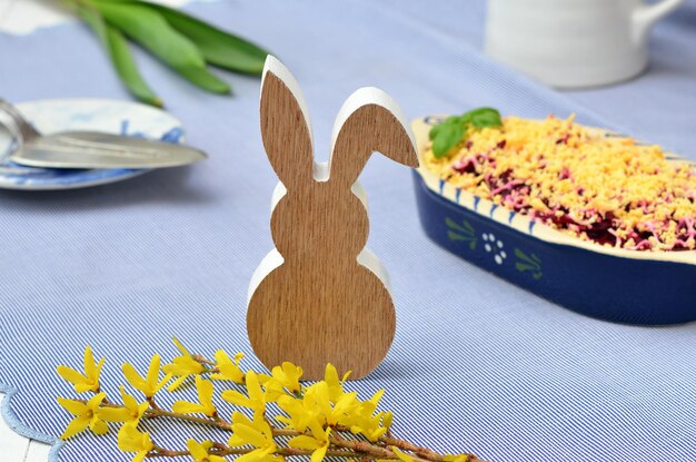 Foto decorazione pasquale coniglietto e rami di forsythia sul tavolo festivo