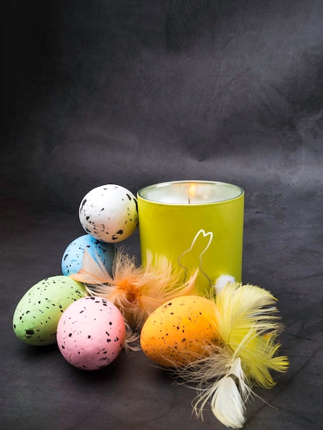 부활절 장식 다채로운 계란과 토끼와 불타는 촛불