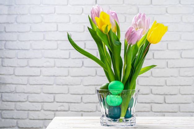 Easter decoration. Flower bouquet with colored eggs