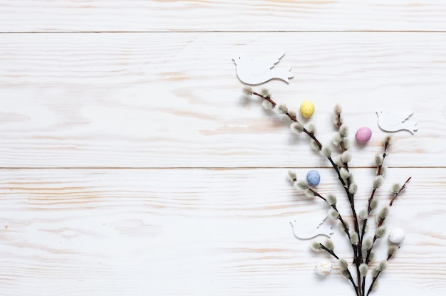 Easter decoration pattern of colorful decorative eggs and dove figurines on willow branches. 