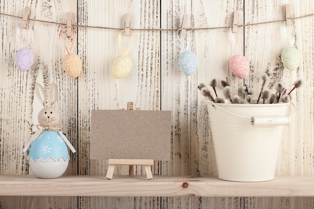 Easter decoration with blank card on wooden background