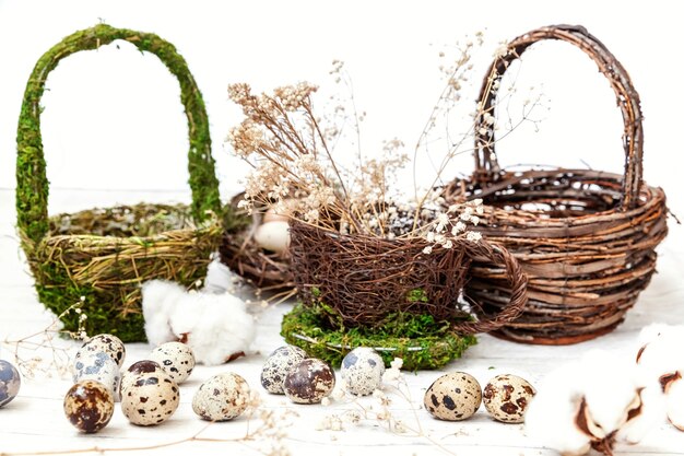 Easter decoration with eggs and basket on white wooden background