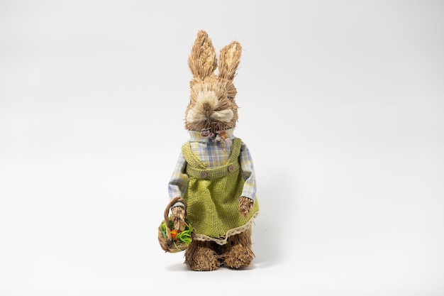 Photo easter decorations hare rabbit of straw easter toy rabbit made of straw with a basket isolated on a white background