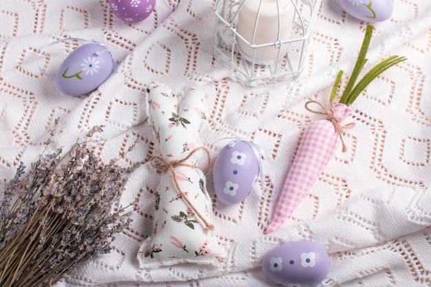 Easter decorations on the table a white knitted napkin Table decoration rabbit carrot and painted eggs