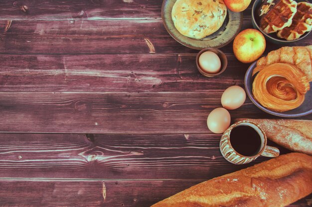 Easter decorations with eggs and breads on vintage wooden background