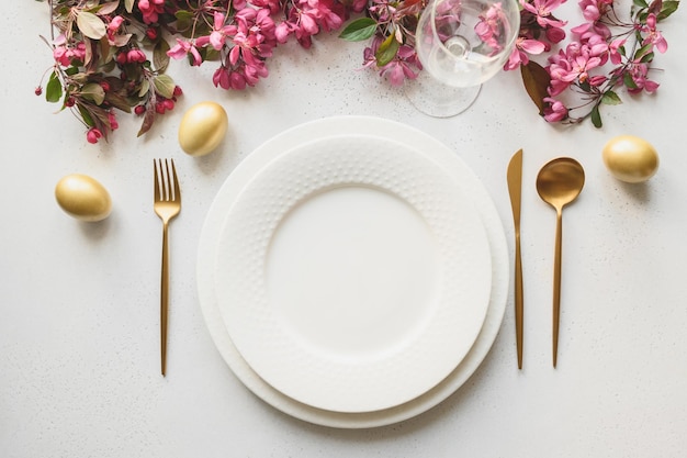 달걀 토끼 축제 식기와 흰색 튤립이 있는 부활절 저녁 식사