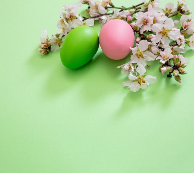 부활절 달걀과 아몬드 꽃 봄 자연 평면 누워 파스텔 녹색 배경