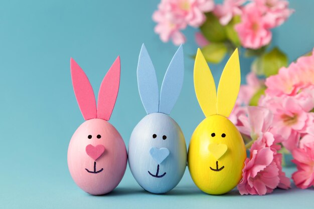 Easter egg bunny ears on blue background DIY decoration Happy Easter Craft concept