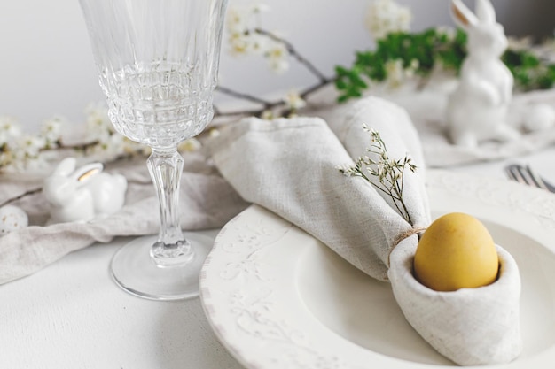 Easter egg in bunny napkin plate cutlery flowers Stylish elegant Easter brunch table setting