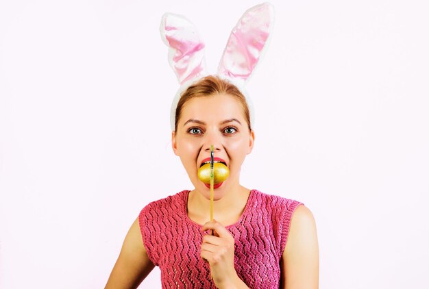 Easter egg ideas egg hunt woman in bunny ears with painted egg in mouth spring holidays