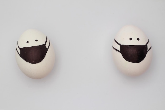Пасхальное яйцо на медицинских масках на черном фоне Пасхальный фонКреативные пасхальные яйца с защитой от коронавируса яйцо в черной маске в карантине