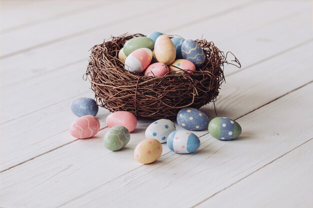 Easter egg and nest on wood table background with copy space.