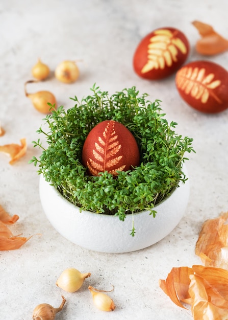 Easter egg with pattern leaves in a traditional rustic style in cress nest