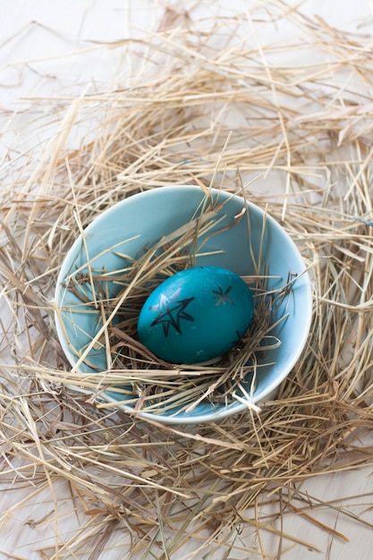 Photo easter egg with straw in a bowl