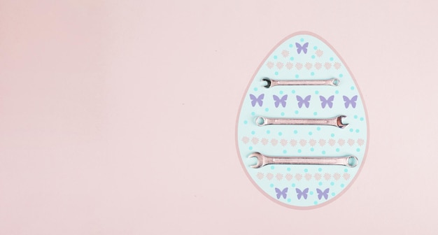 Photo easter egg with wrenches and butterflies, holiday greeting card with repair tools, spring season