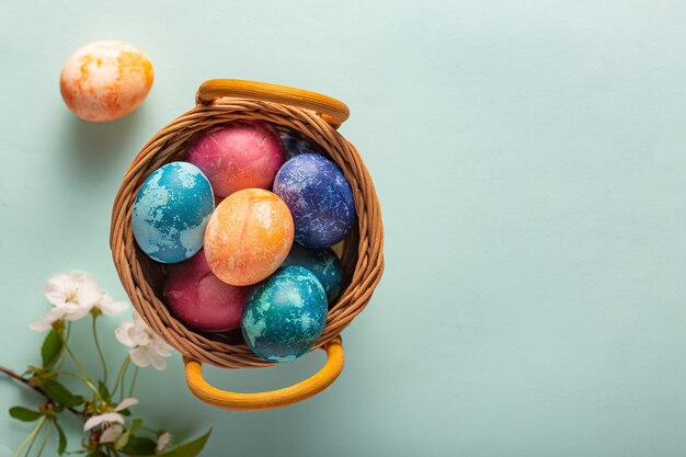 Easter eggs in a basket on a blue background