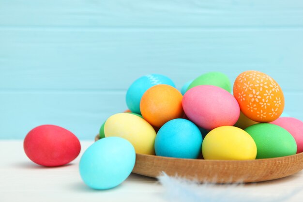 Easter eggs in a basket and flowers on the table