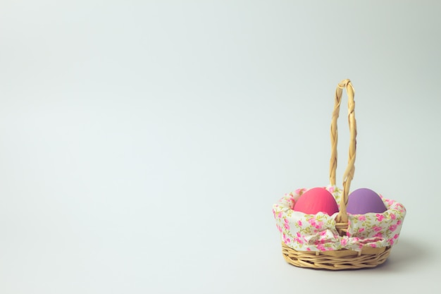 Photo easter eggs in a basket weave wood on the right corner on white.