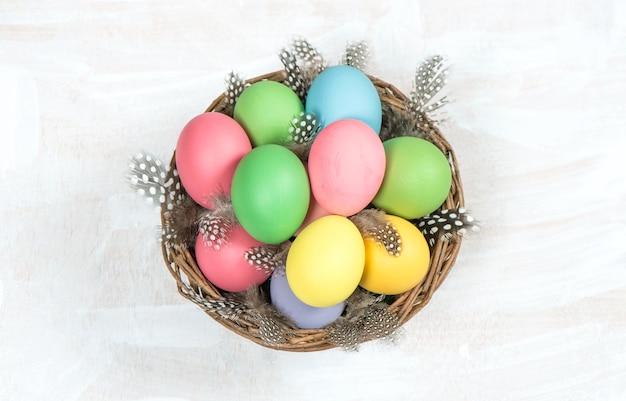 Easter eggs in basket with feather decoration