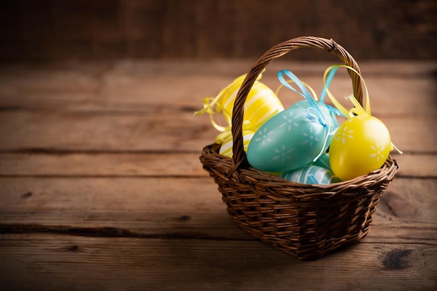 Easter eggs in the basket of wooden boards close up