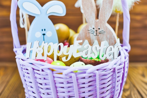 Photo easter eggs in the basket of wooden boards yellow chicks on a  wooden background the minimal concept an easter card with a copy of the place for the text